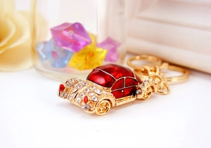 Detailed view of car-shaped keychain with red enamel and inlaid sparkling rhinestones