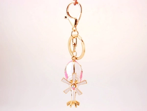 Detail of pink and white enamel helicopter keychain with gold-plated lobster clasp