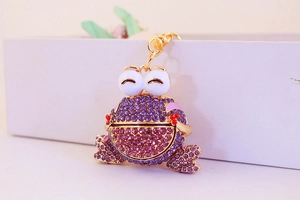 Détail du porte-clés grenouille avec strass violets et compartiment de rangement articulé