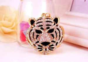 Vue macro d'un porte-clés tigre plaqué or avec strass blancs et décor festif
