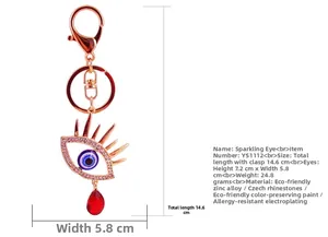 Détail du porte-clés Oeil du Diable en or rose avec cristaux et gemme rouge