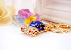 Macro view of blue enamel car keychain with sparkling white rhinestones and golden base