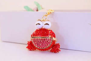 Détail du porte-clés grenouille en cristal rouge scintillant avec fermoir mousqueton doré