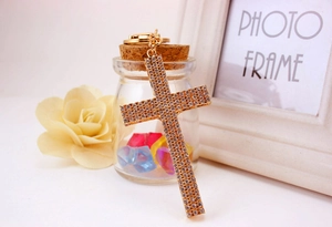 Close-up of golden cross keychain with four rows of sparkling rhinestones inlay