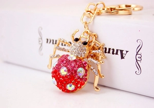 Close-up of sparkling colorful rhinestones on a gold spider keychain with lobster clasp
