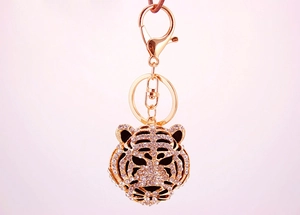 Détail d'un porte-clés tête de tigre doré serti de strass brillants et fermoir