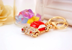 Detailed macro view of a red car keychain with sparkling crystals and gold lobster clasp