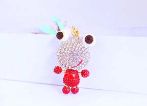 Vue macro du porte-clés grenouille orné de strass brillants blancs et rouges
