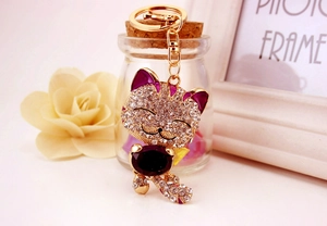 Détail du porte-clés chat porte-bonheur scintillant avec cristal violet et alliage doré