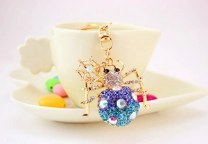 Macro shot of colorful rhinestone spider keychain with gold alloy and spiderweb charm