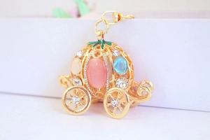 Macro shot of pumpkin carriage keychain with pink gemstones and glittering rhinestones