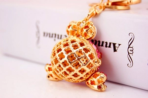 Gros plan du pendentif porte-clés doré en forme de trèfle avec strass roses