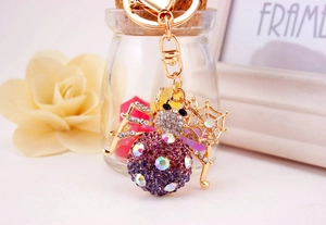 Close-up of golden spider keychain with colorful rhinestones and mini web charm detail