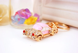 Macro detail of a pink car keychain with crystal rhinestones and gold metal finish