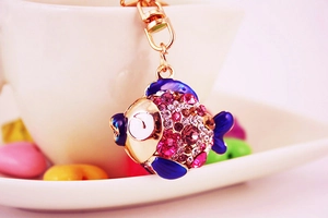 Détail du porte-clés poisson tropical en cristal coloré sur une tasse blanche