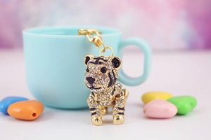 Dettaglio portachiavi tigre dorata con strass di cristallo su una tazza in ceramica