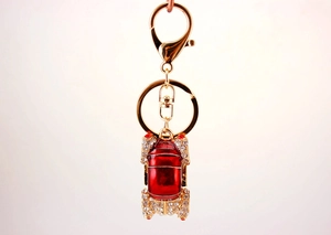 Detailed view of red enamel car keychain with sparkling rhinestones and gold lobster clasp