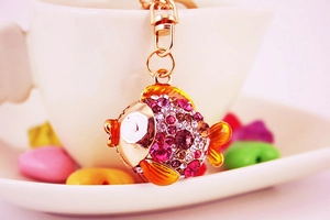 Détail d'un porte-clés poisson en strass avec des cristaux roses et des nageoires oranges