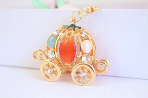 Macro shot of gold pumpkin carriage keychain with rhinestones and colorful gemstones