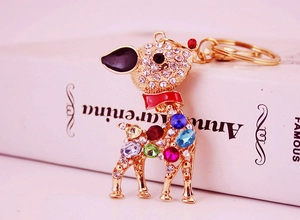 Detail of a gold alloy deer keychain with multi-colored rhinestones and enamel bow