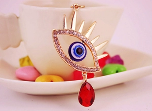 Détail du pendentif œil maléfique avec strass et pierre précieuse rouge en forme de poire