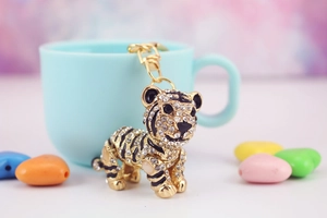 Dettaglio ravvicinato di un portachiavi a forma di tigre 3D con strass e placcatura in oro