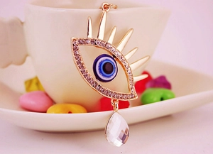 Détail macro du pendentif Œil de protection avec larme en cristal et strass sur tasse