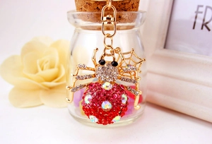 Macro shot of colorful rhinestone spider keychain with gradient pink crystals and gold base