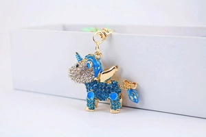 Close-up of sparkling blue and white crystal encrusted unicorn keychain with golden clasp