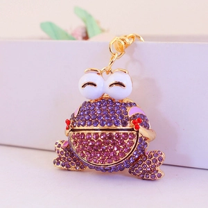 Porte-clés grenouille étincelant avec strass violets sur un cadre en métal doré