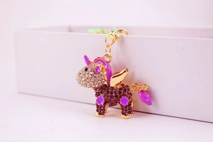 Detailed close-up of a sparkling unicorn keychain with purple rhinestones and gold alloy