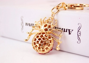 Detailed macro view of a gold spider keychain featuring colorful inlaid rhinestones