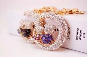 Macro detail of gold moon keychain featuring sparkling purple rhinestone bears