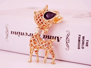 Detailed close-up of golden hollow-out metal reindeer keychain with elegant bow and enamel eyes