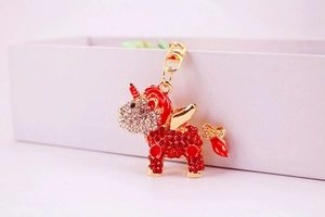 Detailed close-up of a unicorn keychain with red crystals and golden wings