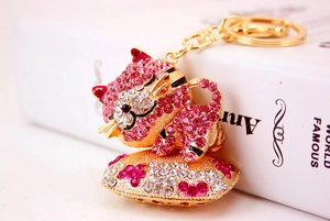 Macro di portachiavi a forma di gatto dorato con strass rosa e trasparenti su base cuore