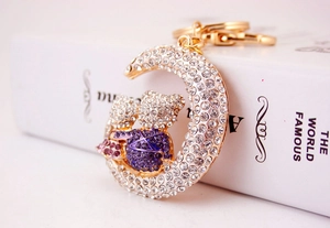 Close-up of sparkling diamond moon bear keychain with gold plating and white rhinestones