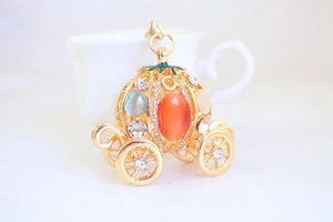 Detailed macro view of crystal pumpkin carriage charm with colorful rhinestones