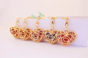 Detail of heart-shaped keychains with colorful rhinestones and rose patterns