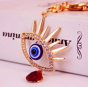 Porte-clés œil maléfique doré serti de zircons et pendentif goutte de cristal rouge