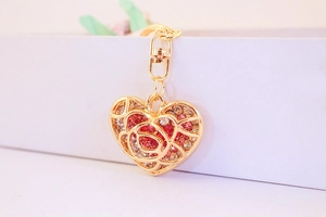 Close-up of heart keychain with hollow rose pattern and sparkling pink rhinestones