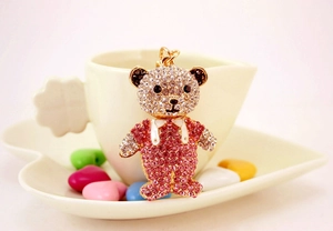 Gros plan du porte-clés ours en strass rose à côté d'une tasse à café pour une idée cadeau