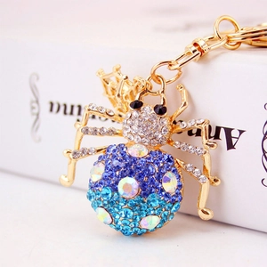 Colorful crystal spider keychain with gold alloy finish and vibrant rhinestones on a gift box