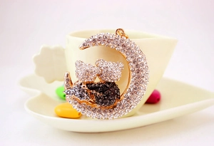 Close-up of the moon and twin cat pendant with sparkling rhinestones and alloy finish