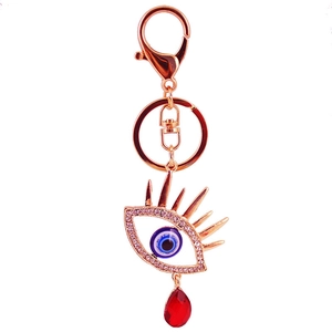 Porte-clés œil protecteur or rose avec cils sertis et goutte de cristal rouge
