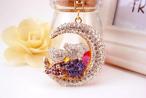 Detailed view of moon bear keychain featuring sparkling purple and white rhinestones