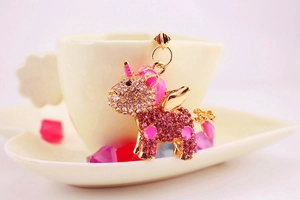 Detail shot of unicorn keychain pendant with pink rhinestones and gold metal wings