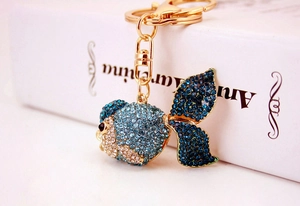 Detailed close-up of a goldfish keychain with blue rhinestones on a gold alloy base