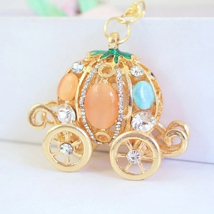 Golden pumpkin carriage keychain with orange and blue gemstones and sparkling rhinestones