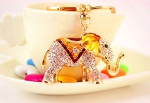 Gros plan d'un porte-clés éléphant doré avec strass scintillants et motifs en émail coloré